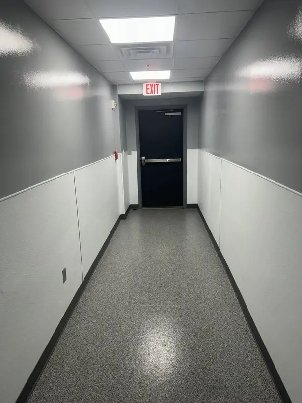Corridor to exit — continuous run with a dark cove base — epoxy flake flooring by Vibrant Painting, Greenville SC